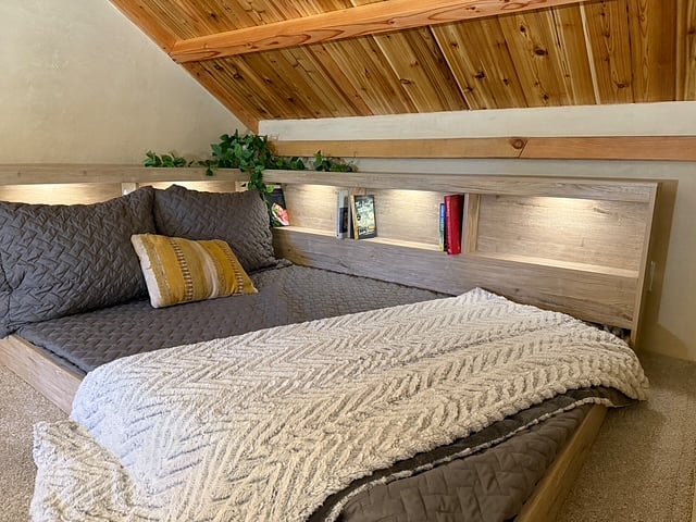 Cozy sleeping loft accessed via stairs. Full bed.