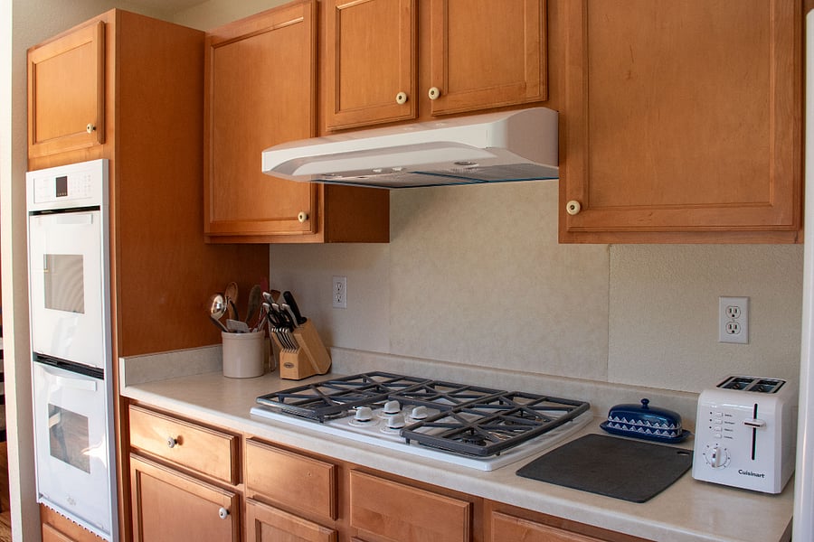 Gas range with hood. Toaster, knives and utensils.