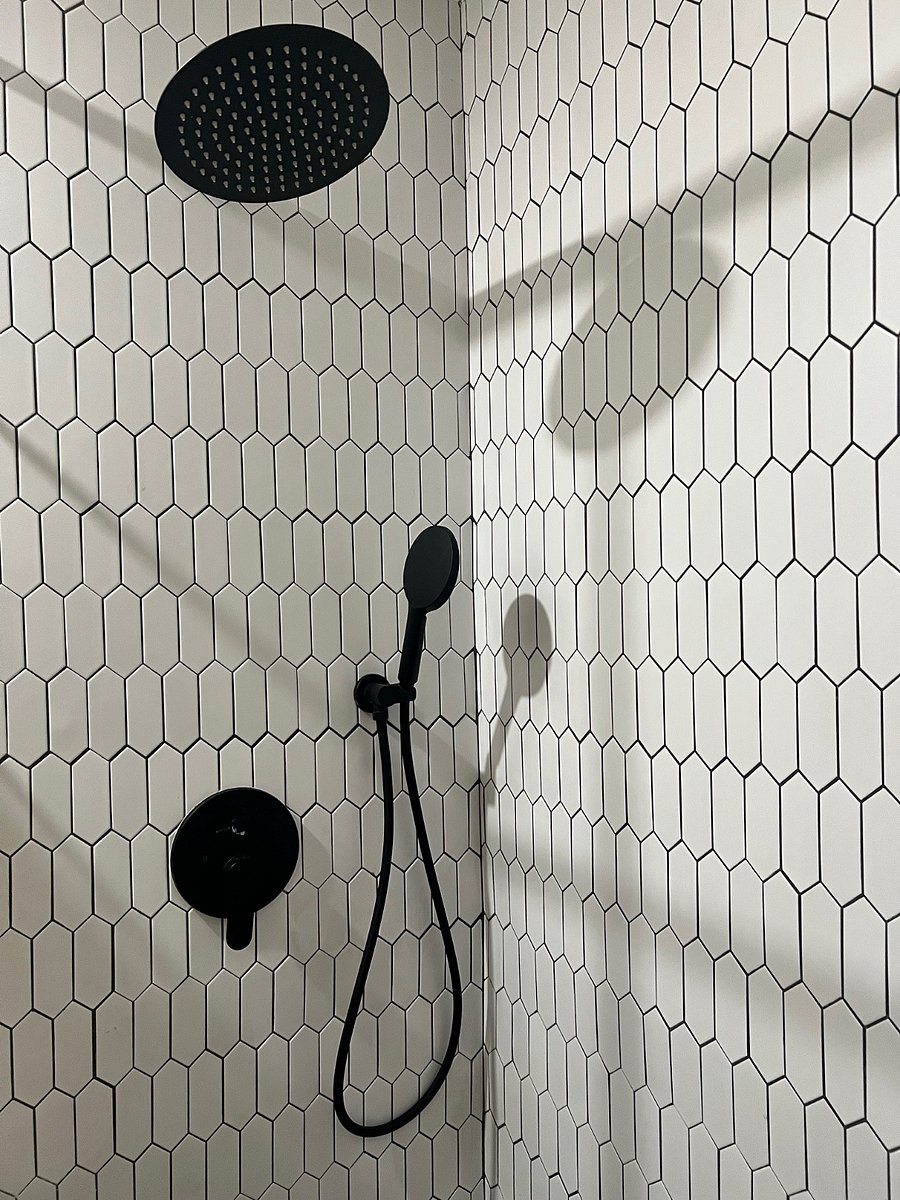Rain shower has adjustable head and separate sprayer. 