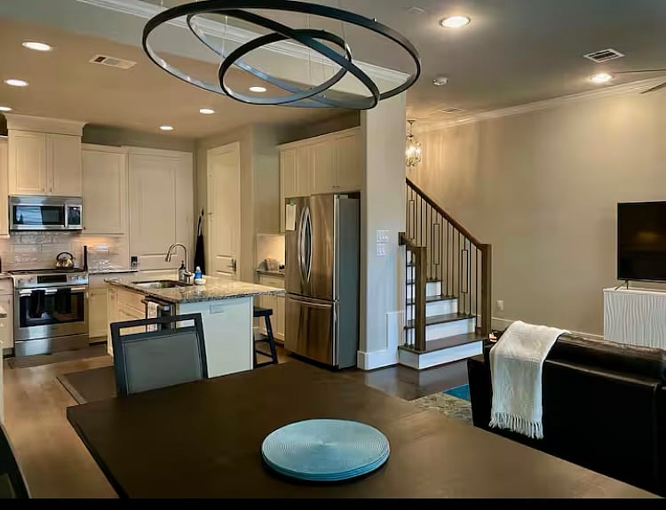Living room, dining area, kitchen, and half bath behind stairs on main level, 2 car attached garage off kitchen
