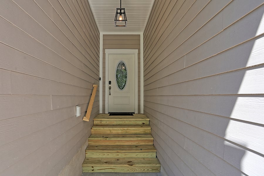 A warm welcome awaits beneath the comfort of this classic covered entryway.