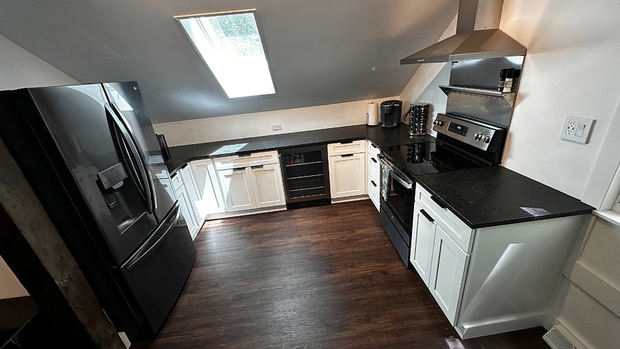 Full kitchen with large fridge freezer, microwave, oven, electric stove top, kettle and coffee maker.