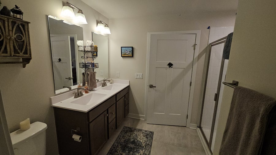 tiled walk-in shower with bench seating. Double sinks.