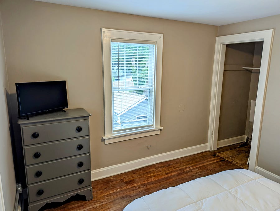 Rear bedroom with closet, dresser and smart TV