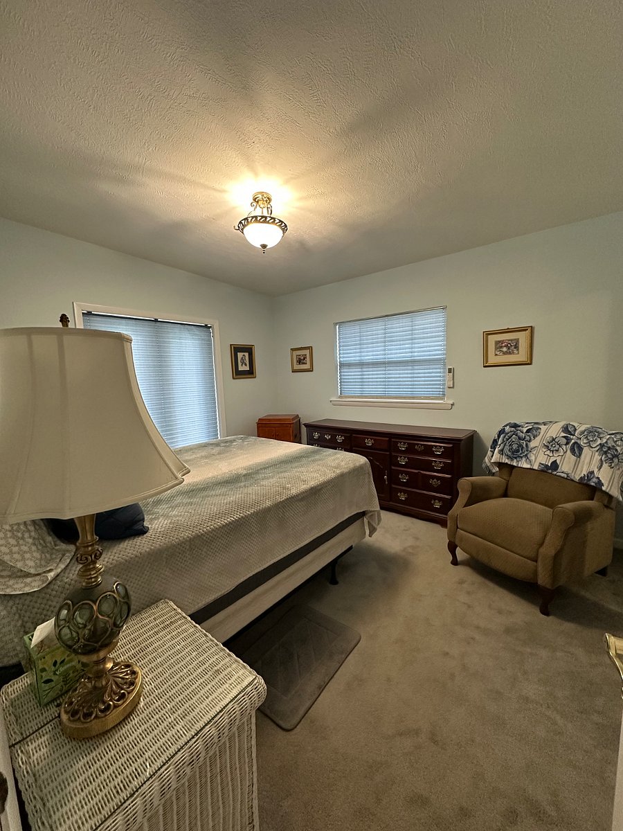 Master bedroom with blinds closed and overhead light on.