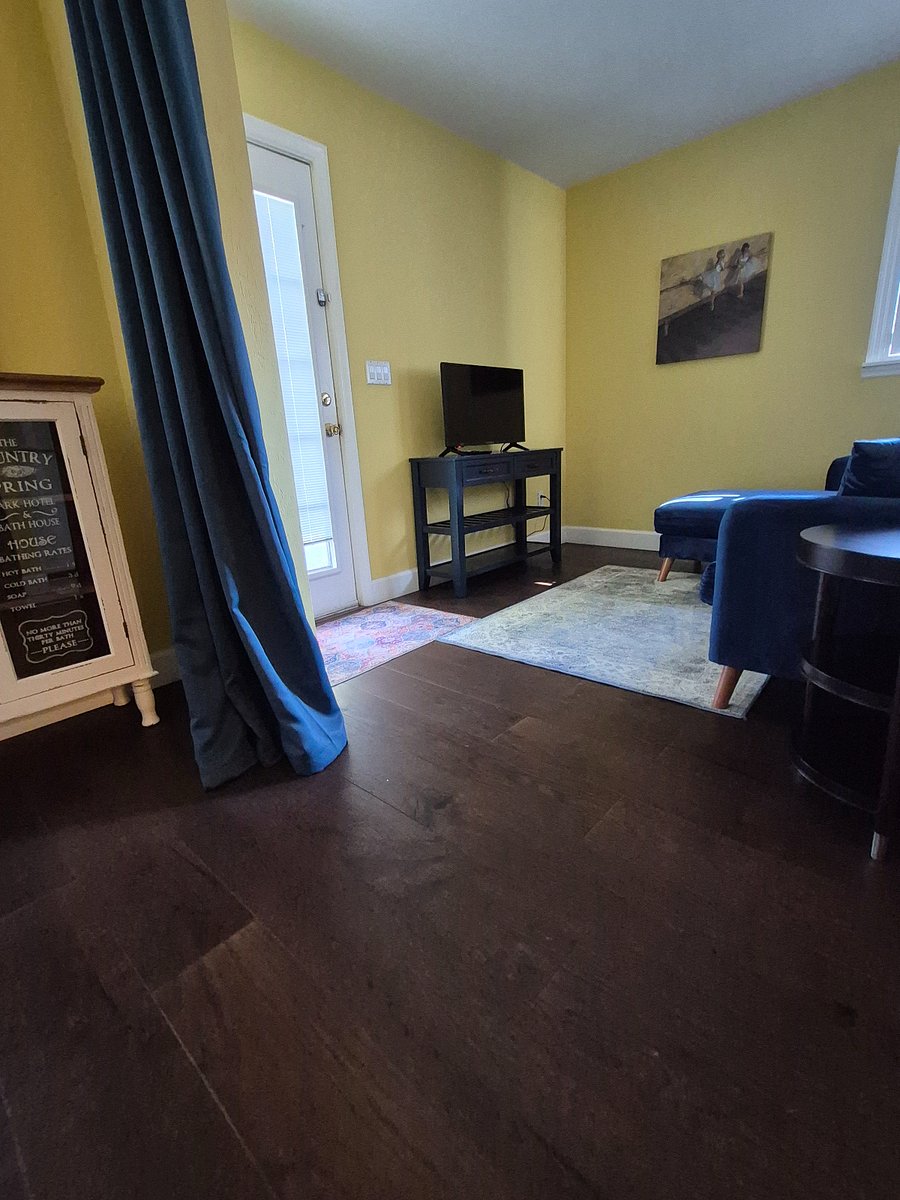 sitting area with smart TV and black out curtains between sitting area and bed area