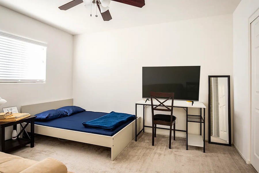 The Sapphire Room with queen size bed, futon, workspace, and Smart TV.