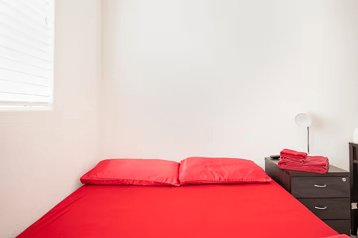 The Ruby Room with queen size bed, workspace, and Smart TV.