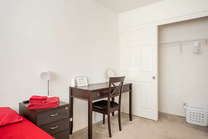 The Ruby Room with queen size bed, workspace, and Smart TV.