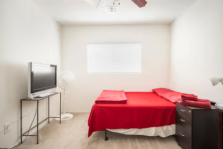 The Ruby Room with queen size bed, workspace, and Smart TV.