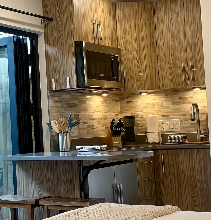 Full kitchen with custom quartz countertops, cabinets and tile backsplash.