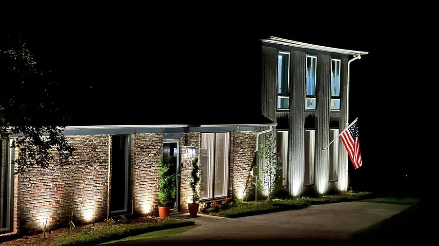 The exterior of the house is lighted at night.