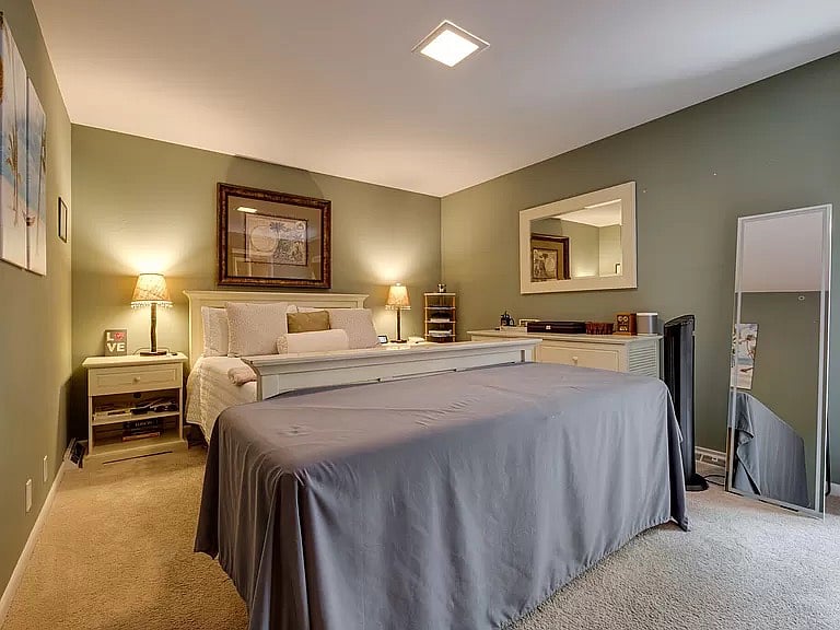 A view of the master bedroom from the hall door. The massage table is not included. There is a door (with a window) to the deck. Typically not used, but provides emergency egress if needed.