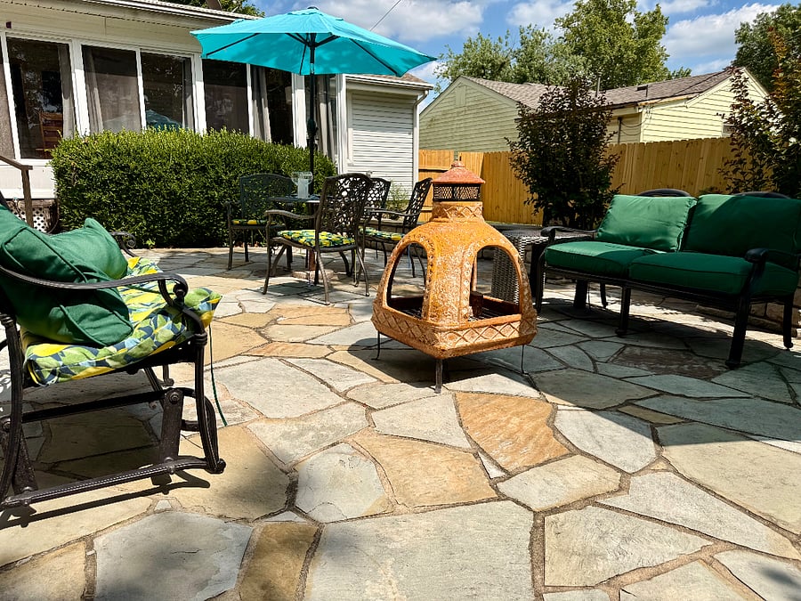 Large stone patio with Chiminia, 0utdoor furniture and propane grill.