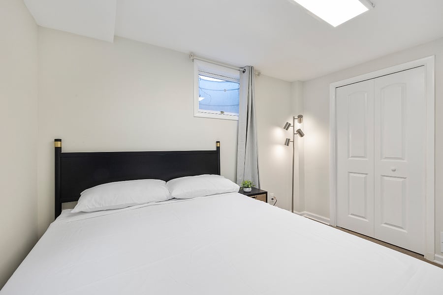 First bedroom with two windows, blackout curtains, and full-size bed  bright and restful.