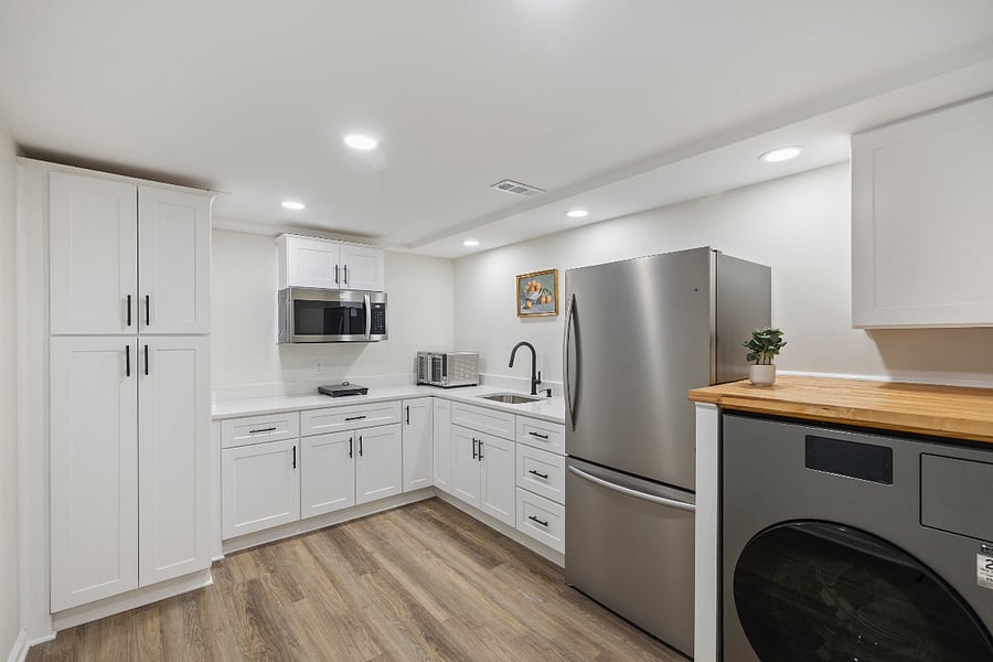  Fully equipped kitchen with quartz counters, induction stove, microwave, air-fryer, stainless appliances, and a smart LG washer/dryer combo.