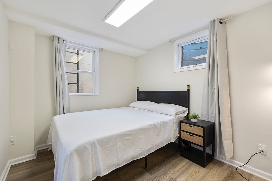First bedroom with two windows, blackout curtains, and full-size bed  bright and restful.