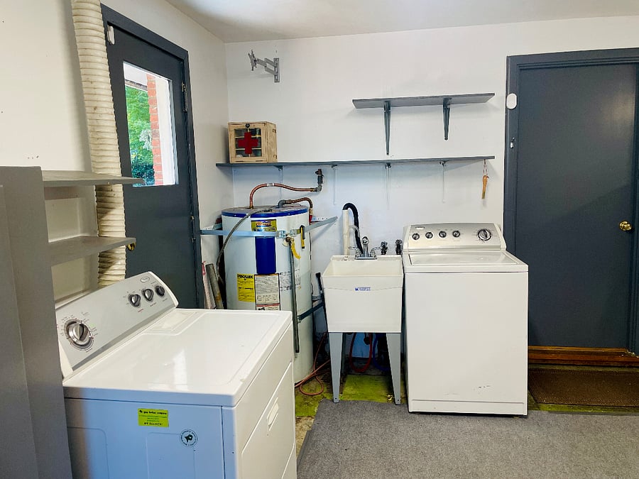 Washer, drier, and sink. Right door leads to kitchen. Left door exits to the side of the home.