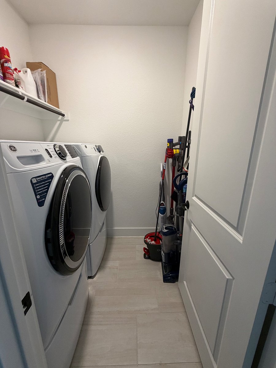 Large laundry room with full-sized front load GE washer and dryer