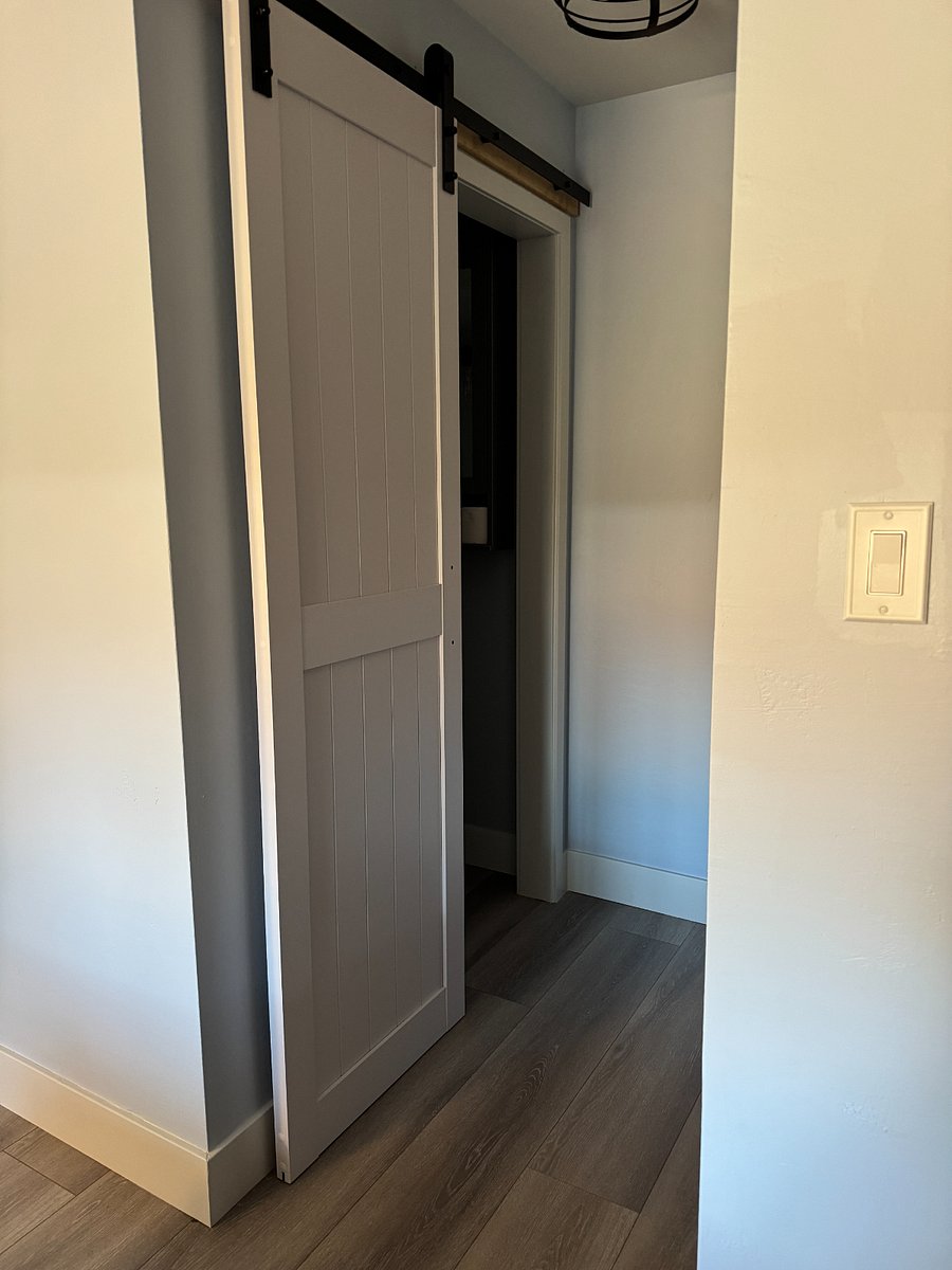 Interior barn door to attached private half bathroom