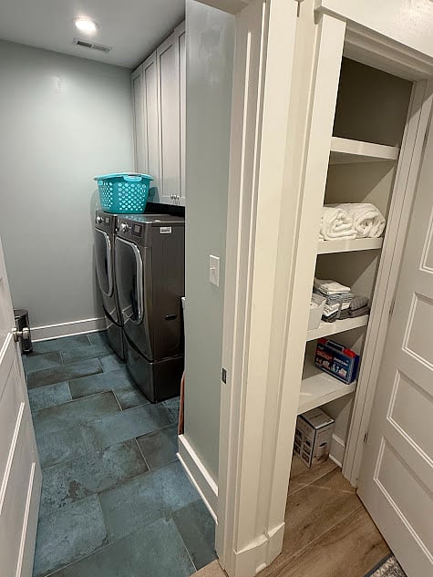 Laundry room with front-loading washer and dryer. Linen closet off hallway.