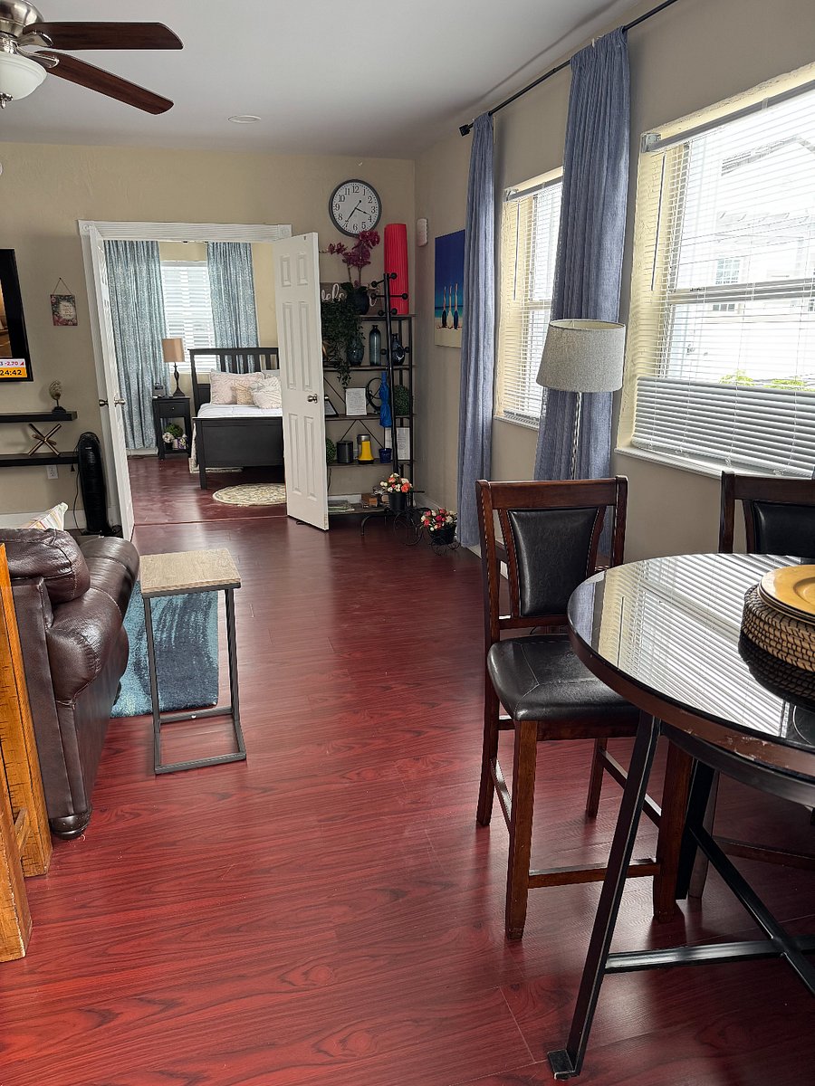Living room, dining table, and bedroom in back ground