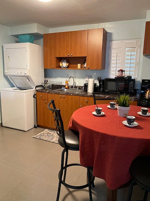 Kitchen: Washer dryer combo - microwave, coffee maker, glasses, dishes, full kitchen utencils in top cabinets, cleaning supplies in bottom cabinets.