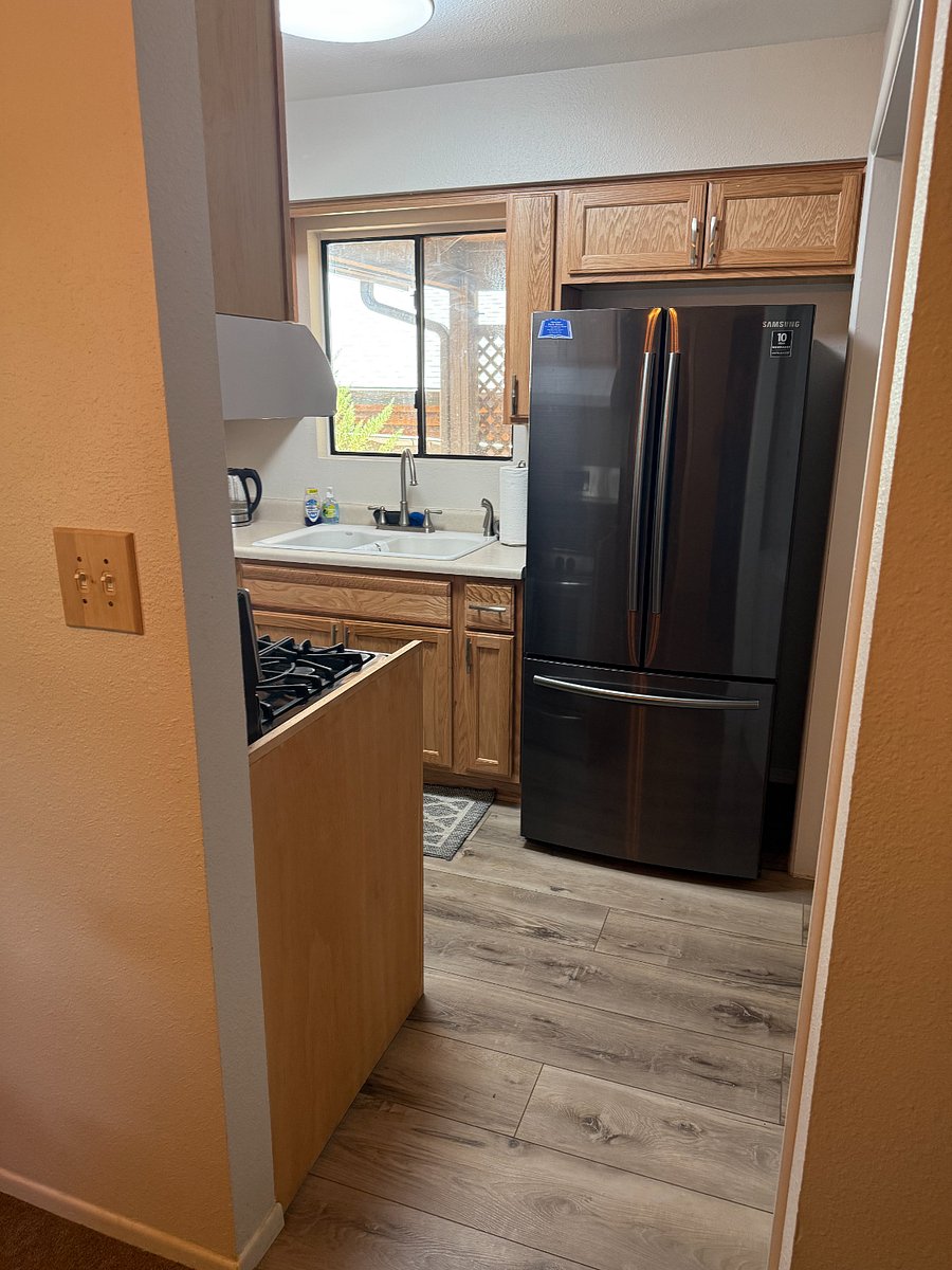 Kitchen with Double Door Black Stainless Steel Refrigerator.