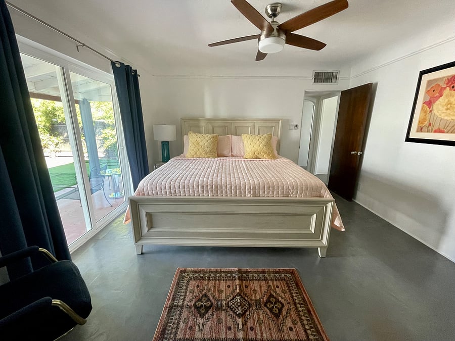 Main bedroom offers a king size bed with plush bedding and beautiful views of the backyard.
