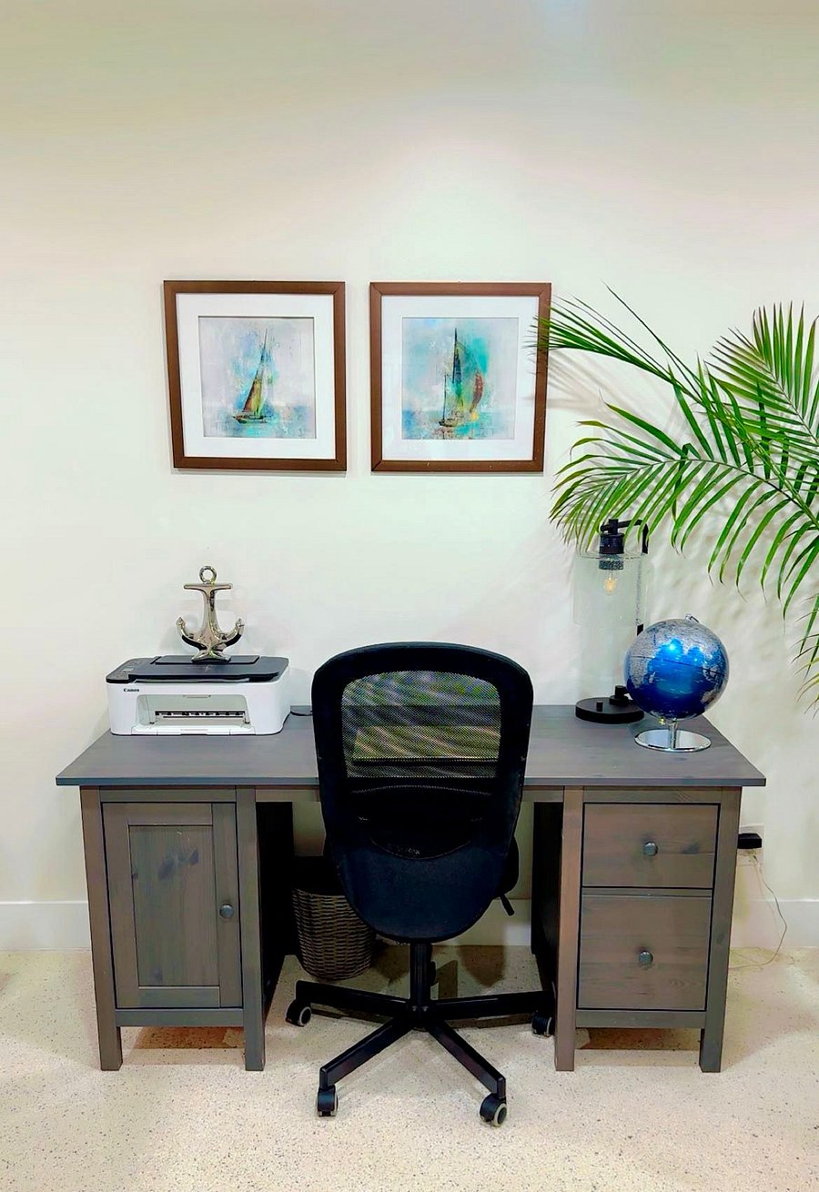 Work Without Disrupting the Vibe
A quiet desk setup sits just to the side perfect for remote work, planning, or printing out tomorrows boarding pass. Theres a full-size desk, ergonomic chair, printer, and subtle coastal accents that make the space feel pulled together without feeling like an office.