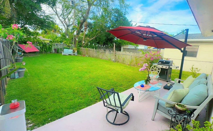 Enjoy a colorful hammock under the string lights, a cantilever umbrella for shade, and a cozy sitting area perfect for meals or conversation.