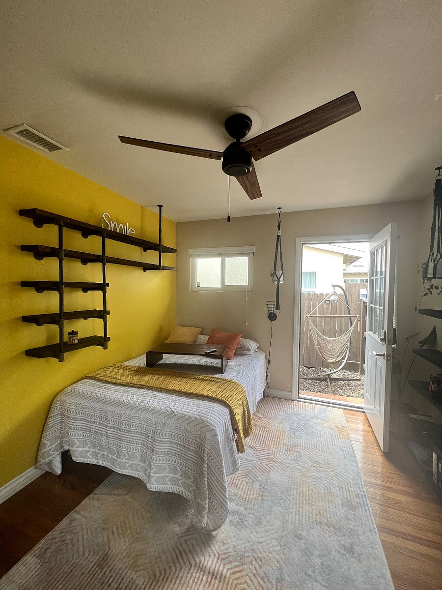 View from the bathroom doorway facing the bed and private entrance to the enclosed dining area private yard. 