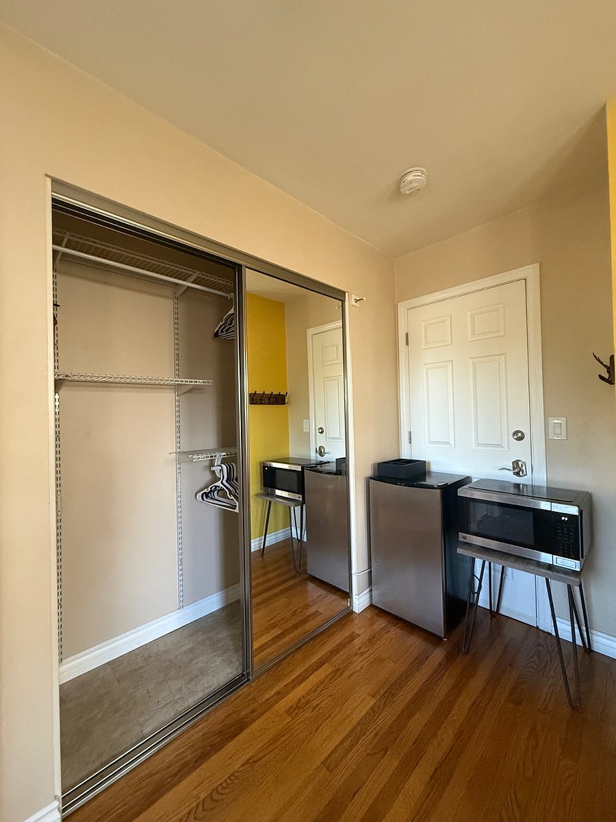 Closet with mirrored doors, mini fridge & convection cooker. 