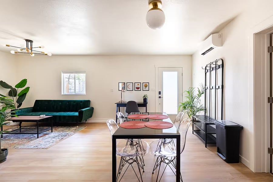 Open living space features a dining table to seat 4 and professional desk space