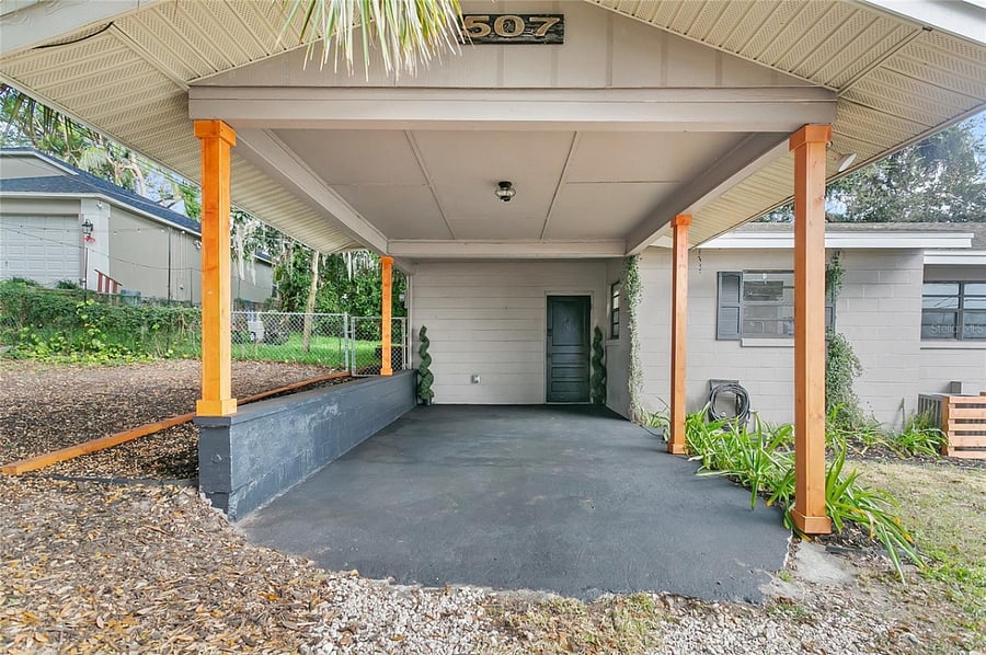 Covered carport.  Keypad door into storage room / laundry room, which then has door which connects to kitchen.