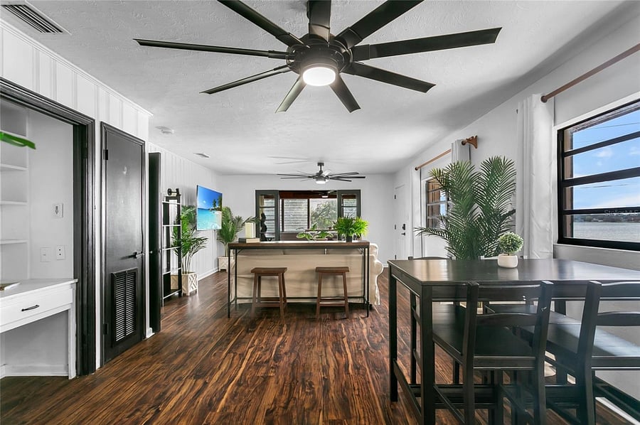 Dining room table next to kitchen and looking towards living room and enclosed outer deck.