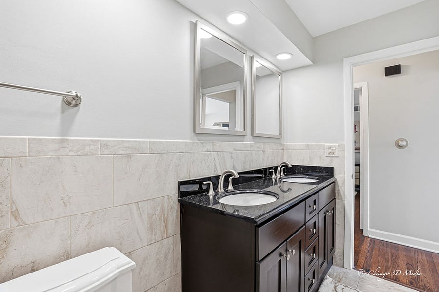 Spacious bath with Jacuzzi tub and sparkling dark granite vanity countertop with double sinks.
