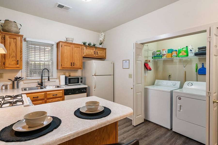 Fully stocked kitchen with stove, oven, dishwasher, refrigerator, microwave, toaster, coffee maker, dishware and cookware.