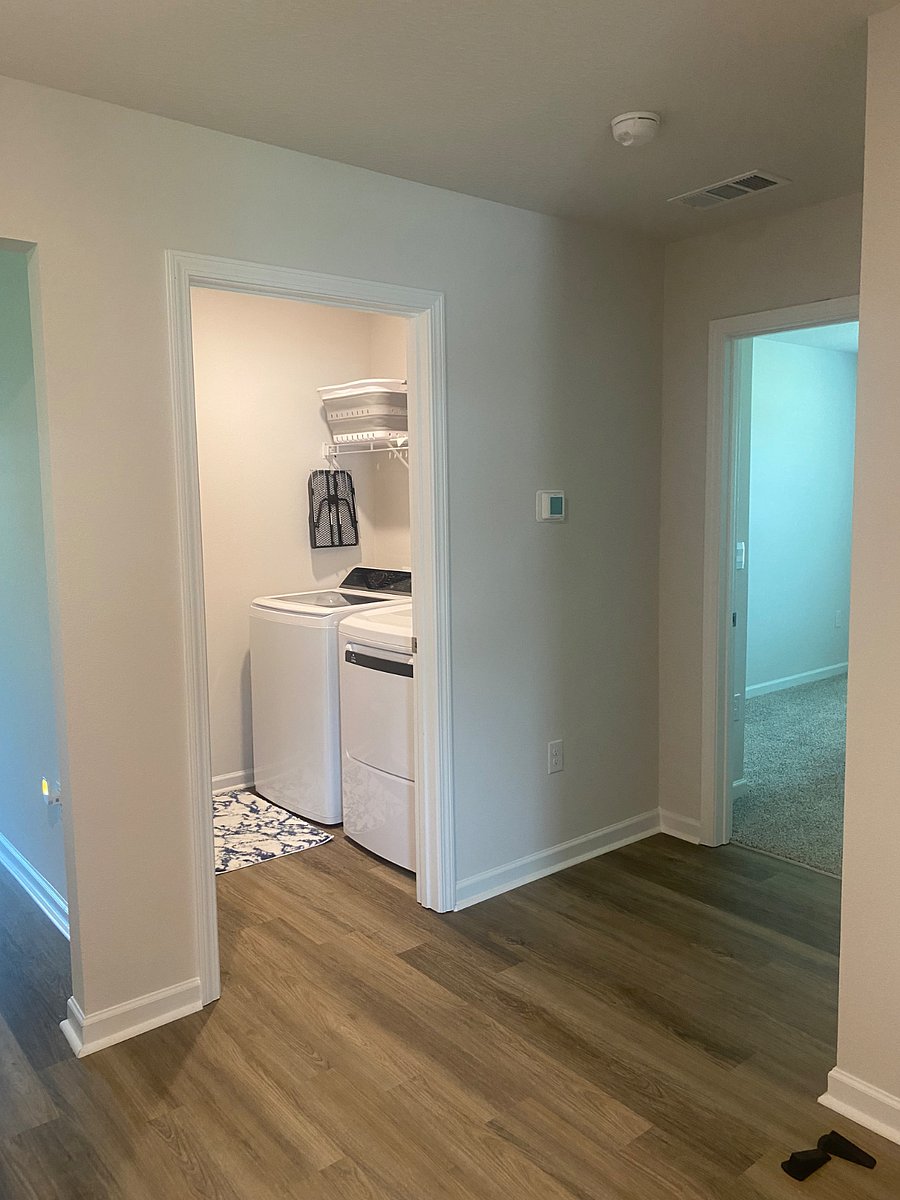 Laundry with full size washer and dryer, iron board and iron. Shelving for linens.