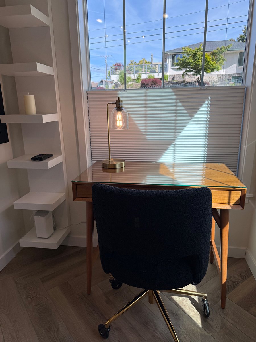 Desk area with overhead and desk light, storage, IKEA shelving, and corkboard.
