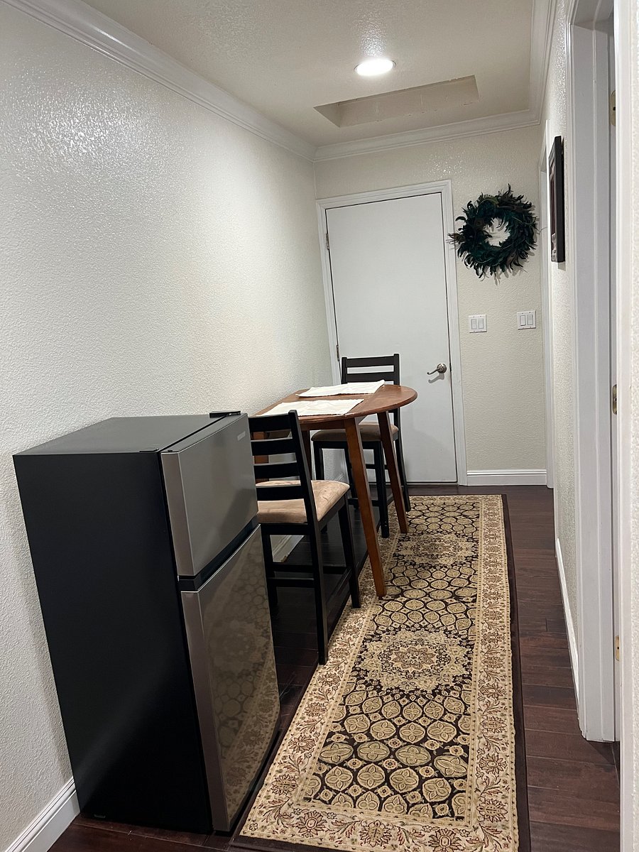Hallway with table and small frig. 