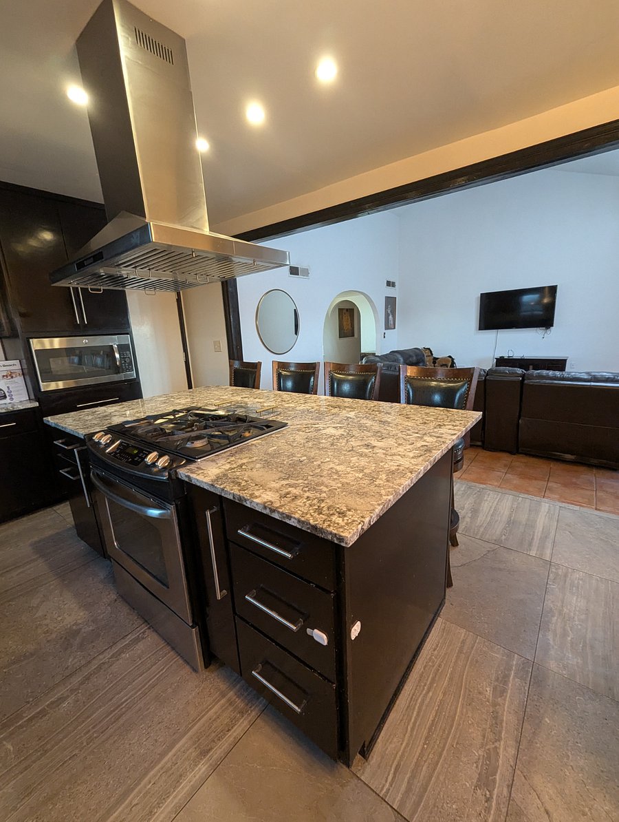 Large island with gas stove and granite countertops