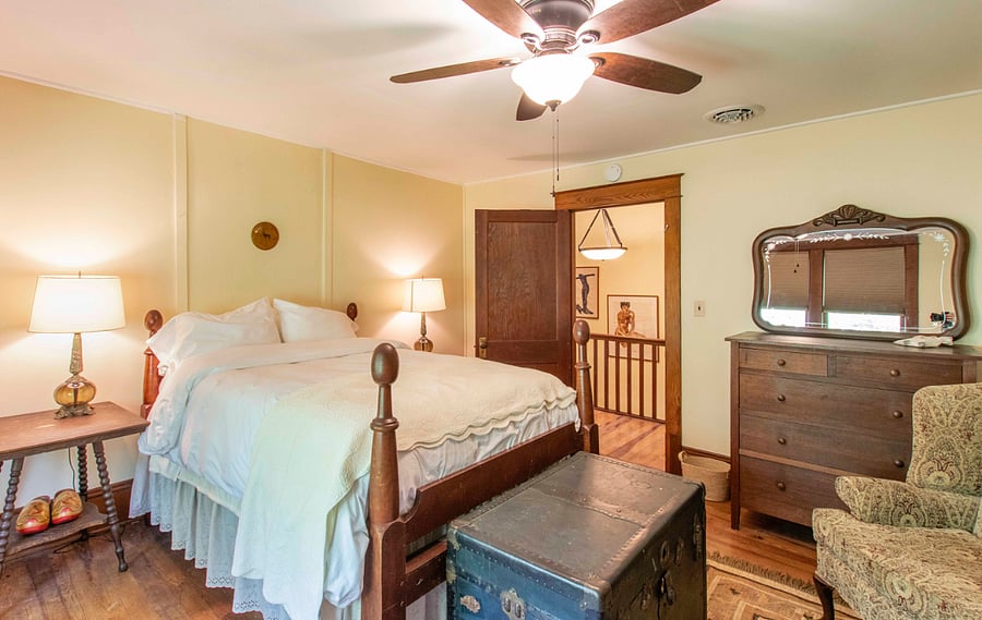 This upstairs bedroom has a double bed, two dressers and a clothing rack