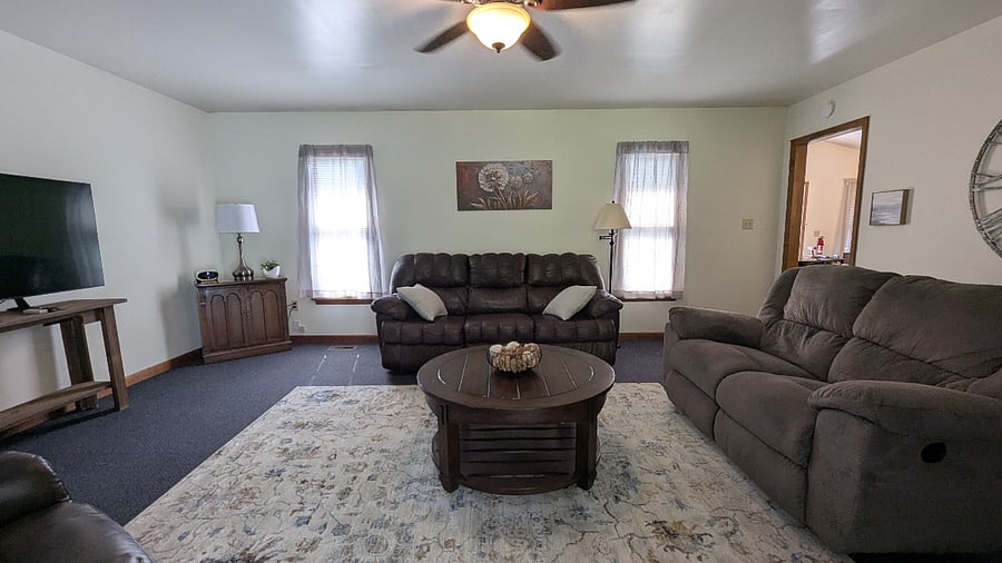 Kick back in the inviting living room featuring a comfortable sitting area, plush seating, and a large smart TV ideal for streaming after a long day. This space is perfect for both unwinding and entertaining.