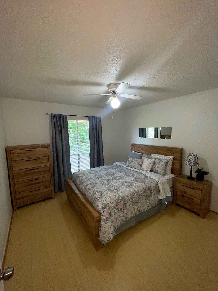 Queen bed with night stand and dresser. Lamp and faux plant. Thick curtains for dark room.
