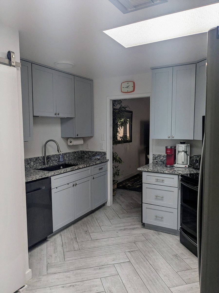 Large kitchen sink with cutting board, drying rack, and versatile faucet. Washer and dryer are hidden away in large kitchen closet.