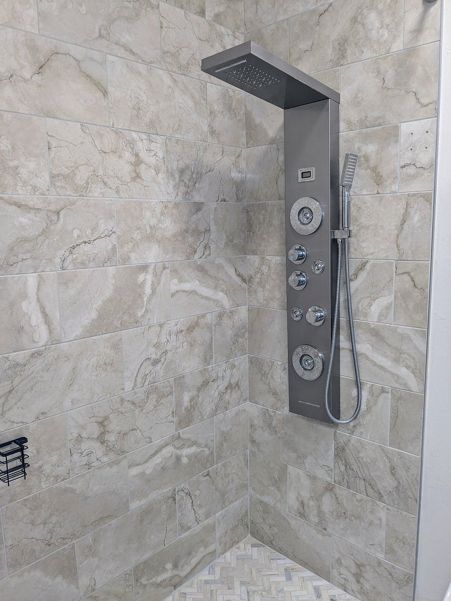 Main bathroom has walk-in column shower with overhead rain. Floor to ceiling tile.