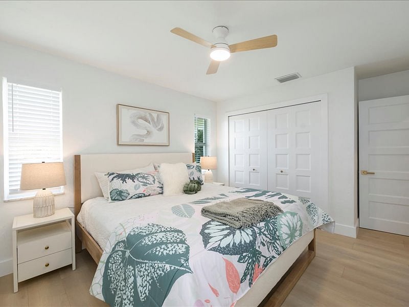Spacious primary bedroom with plush bedding  perfect for extended stays in Naples.