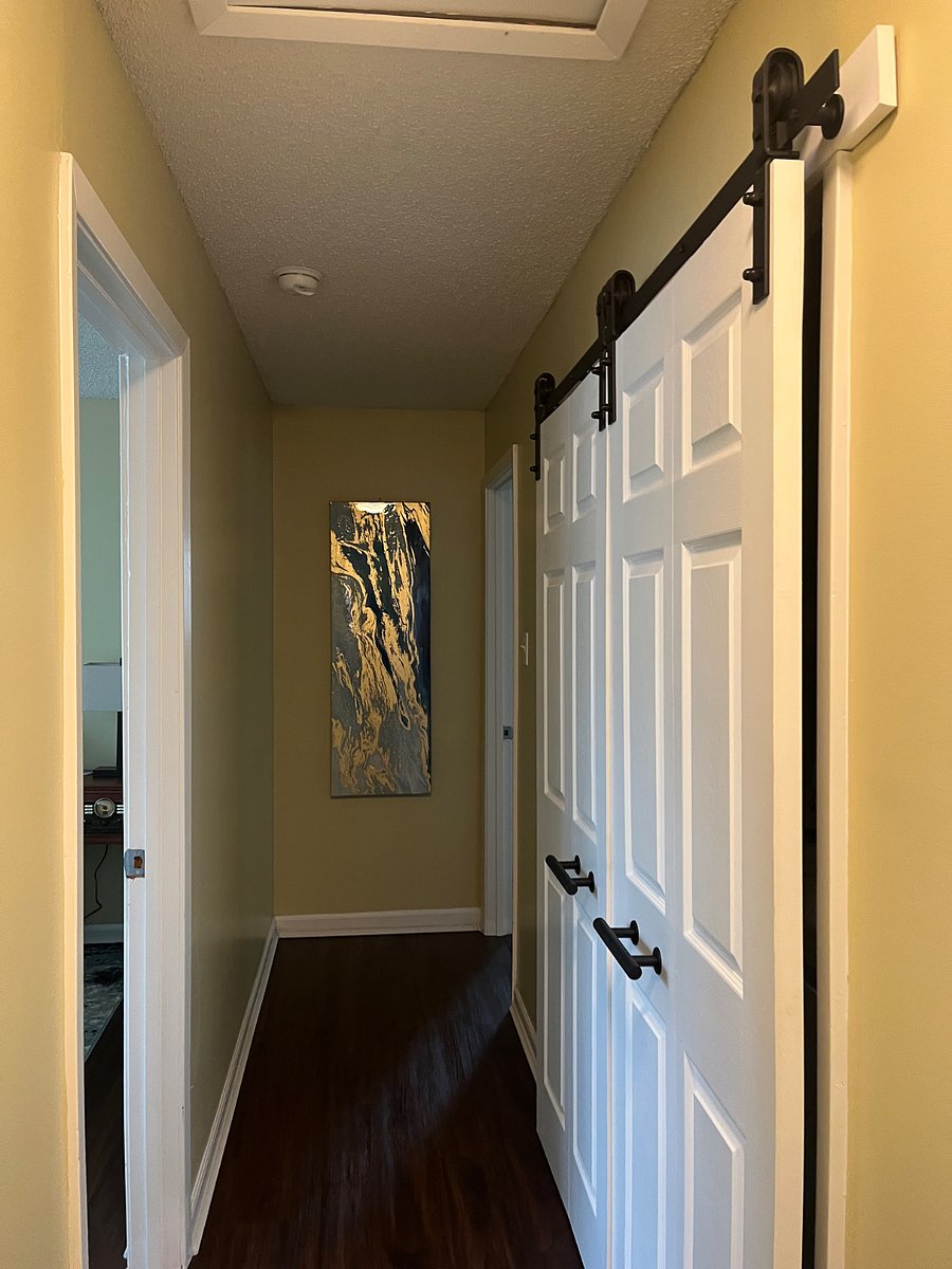 Hallway with two queen bedrooms on left and full bathroom and washer and dryer on right.