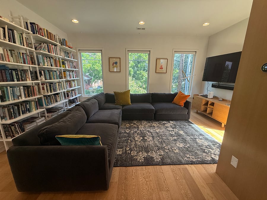 Sun-lit living room, floor-to-ceiling library, 65 4K TV